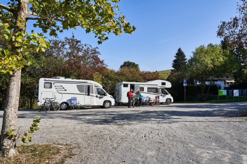 Zwei Wohnmobile parken nebeneinander auf einem Stellplatz.
