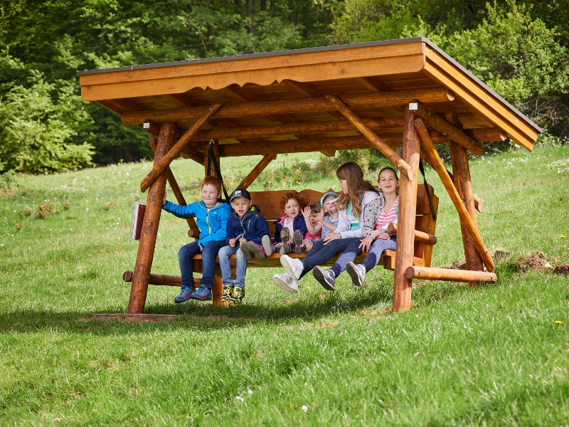 Knaupwiesen Kinder sitzen auf einer Hollywoodschaukel auf den Knaupwiesen